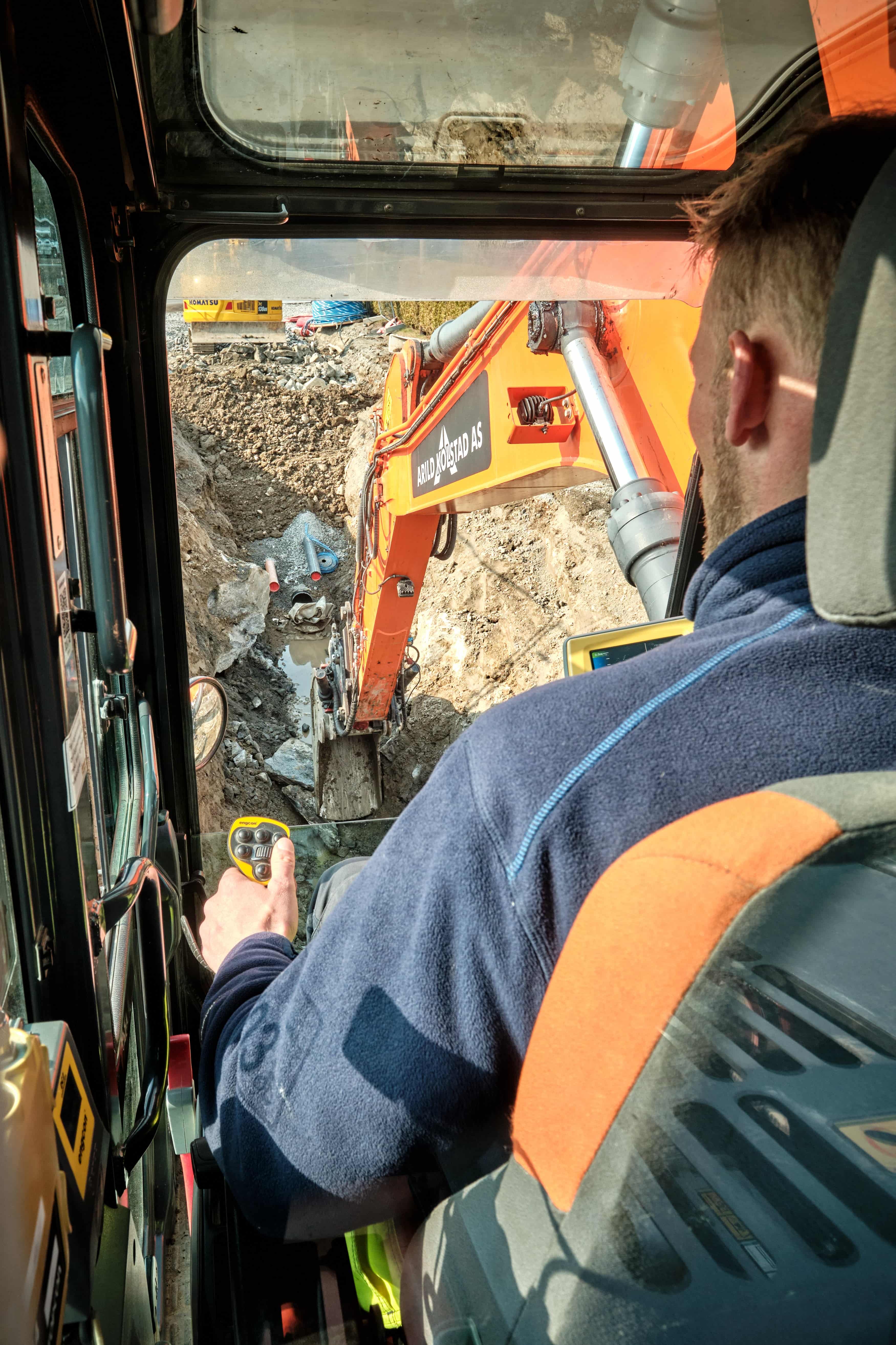 En person som sitter i en gravemasking og jobber